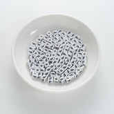 BD00117-01-black-letter-white-opaque-cube-alphabet-beads-single-f-7mm